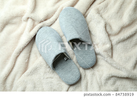Pair of house slippers on plaid background 84738919