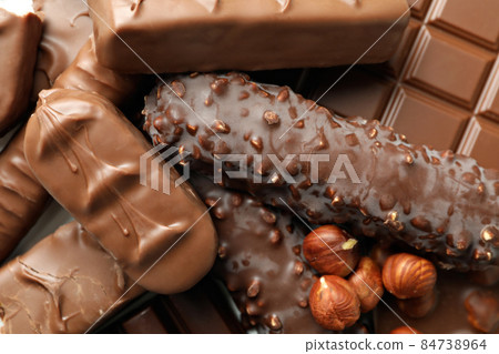 Different tasty candy bars and nuts, close up 84738964