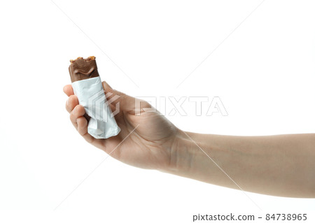 Female hand holds candy bar, isolated on white background 84738965
