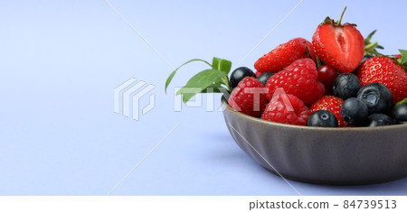 Bowl with berry mix on violet background Bowl with berry mix on violet background 84739513