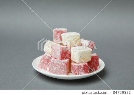 Plate with delicious turkish delight on gray background Plate with delicious turkish delight on gray background 84739582