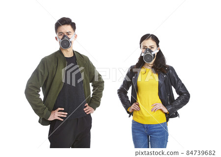 young asian man and woman wearing gas mask staring at camera with arms akimbo, isolated on white young asian man and woman wearing gas mask staring at camera with arms akimbo, isolated on white 84739682