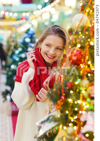 happy blond girl in red scarf close up portrait on decorated Christmas city background happy blond girl in red scarf close up portrait on decorated Christmas city background 84741973