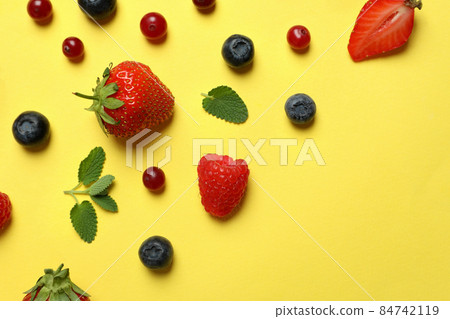 Delicious fresh berry mix on yellow background Delicious fresh berry mix on yellow background 84742119