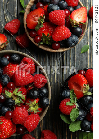 Bowls with berry mix on wooden background Bowls with berry mix on wooden background 84742129