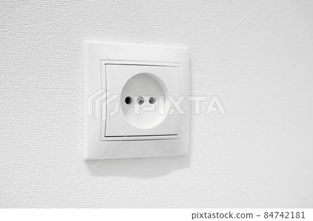German circular recess socket with two round holes for 2 pins europlugs types C, E and F. Common cheap plastic AC power wall outlet. Not grounded European white electrical socket CEE 7 against wall German circular recess socket with two round holes for 2 pins europlugs types C, E and F. Common cheap plastic AC power wall outlet. Not grounded European white electrical socket CEE 7 against wall 84742181