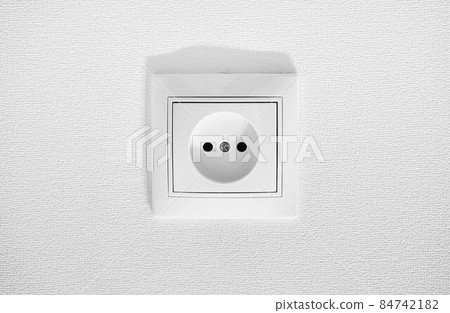 German circular recess socket with two round holes for 2 pins europlugs types C, E and F. Common cheap plastic AC power wall socket. Not grounded European white electrical outlet CEE 7 against wall German circular recess socket with two round holes for 2 pins europlugs types C, E and F. Common cheap plastic AC power wall socket. Not grounded European white electrical outlet CEE 7 against wall 84742182