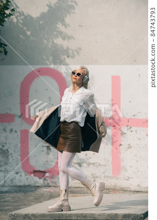 Portrait of blonde woman in headphones and sunglasses . Hipster fashion model wear stylish wireless headphones enjoy listen new cool music. 84743793