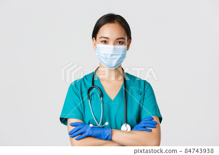 Covid-19, coronavirus disease, healthcare workers concept. Close-up of confident smiling, professional asian doctor, nurse in medical mask and rubber gloves ready for examination, white background 84743938