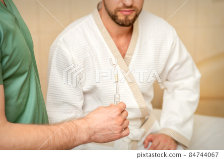 Doctor giving nasal inhalator with essential oil Maholda to a male patient in spa. 84744067