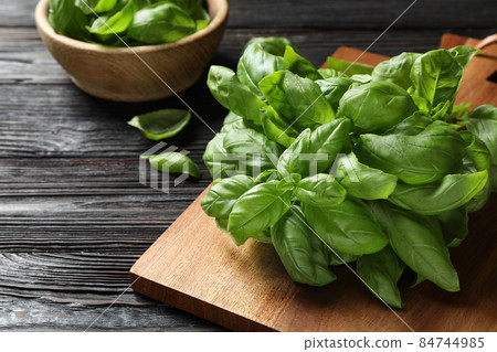 Fresh green basil on black wooden table, closeup Fresh green basil on black wooden table, closeup 84744985