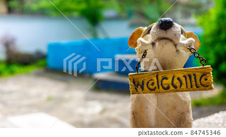 Soft focus toy dog and sign welcome in the garden at house Soft focus toy dog and sign welcome in the garden at house 84745346