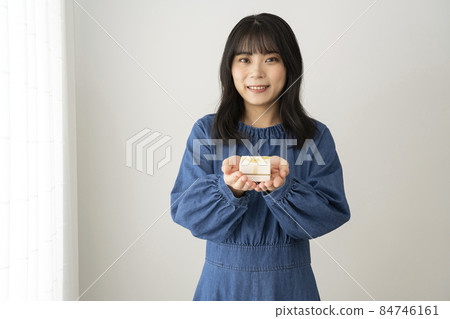 A woman with a small gift box on her palm A woman with a small gift box on her palm 84746161