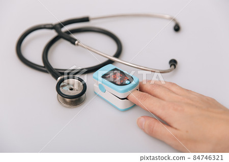 Stethoscope, pulse oximeter and thermometer gun on white background. Treatment of cold or flu. Phonendoscope. Infrared isometric thermometer gun to check body temperature for virus symptoms. Stethoscope, pulse oximeter and thermometer gun on white background. Treatment of cold or flu. Phonendoscope. Infrared isometric thermometer gun to check body temperature for virus symptoms. 84746321