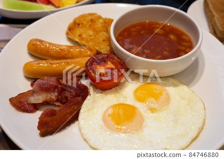 Fried eggs, bacon, sausages, beans, tomatoes for breakfast. Fried eggs, bacon, sausages, beans, tomatoes for breakfast. 84746880