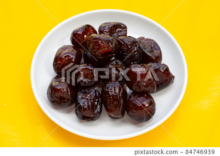 Sweet chinese jujube dessert in white plate on yellow background. 84746939