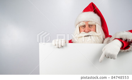 Santa Claus points to an empty white space. Promotional offer for Christmas. Santa Claus points to an empty white space. Promotional offer for Christmas. 84748553