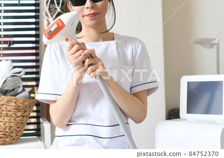 戴護目鏡的脫毛沙龍治療人員的年輕女性 戴護目鏡的脫毛沙龍治療人員的年輕女性 84752370