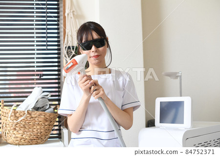 戴護目鏡的脫毛沙龍治療人員的年輕女性 84752371
