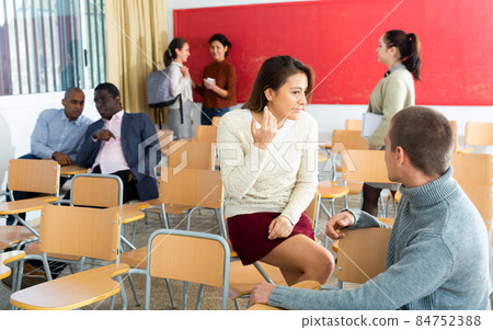 Latin american and caucasian concentrated students discussing assignment during recess 84752388