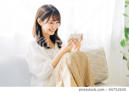 Woman watching video on smartphone 84752630