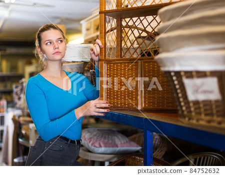 Young woman consumer near wicker commode Young woman consumer near wicker commode 84752632