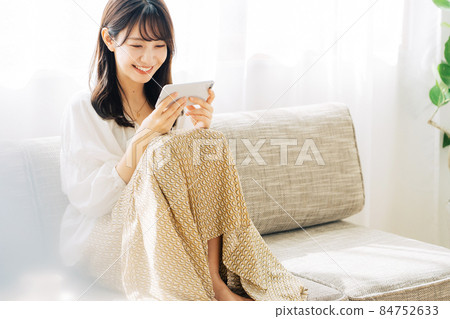 Woman watching video on smartphone Woman watching video on smartphone 84752633