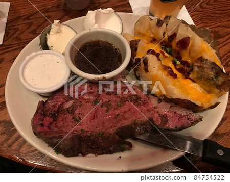 American specialties, prime rib steak and baked potatoes American specialties, prime rib steak and baked potatoes 84754522