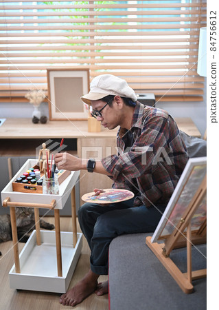 Male artist painting with watercolor at art studio. 84756612