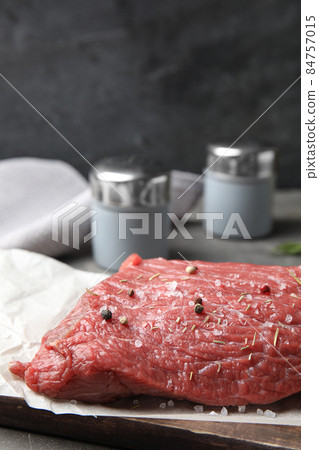 Fresh raw beef cut with spices on table, closeup Fresh raw beef cut with spices on table, closeup 84757015