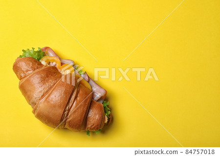 Tasty croissant sandwich with ham on yellow background, top view. Space for text Tasty croissant sandwich with ham on yellow background, top view. Space for text 84757018