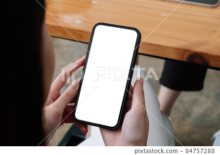 Mock up phone in woman hand showing white screen, female using mobile phone with blank screen for texting, chat. Mock up phone in woman hand showing white screen, female using mobile phone with blank screen for texting, chat. 84757288