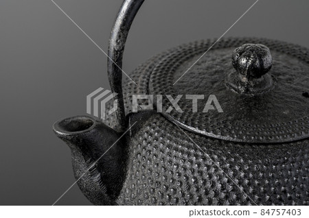 Old iron kettle on a black background Old iron kettle on a black background 84757403
