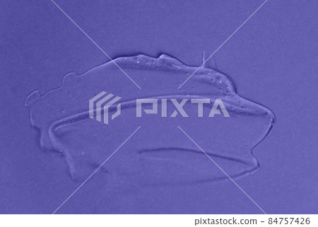 Liquid gel cosmetic product with shimmery particles and bubbles on purple background. Texture and background. Color of the Year 2022 84757426