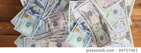 Many different dollar bills lying on wooden table closeup background Many different dollar bills lying on wooden table closeup background 84757461