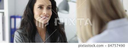 Two business women discussing at table in office 84757490