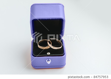 Two beautiful wedding rings on jewelry boxcolored in trendy color of year 2022 Very Peri isolated on white background. Inspired by using color 17-3938, Color of the year concept Two beautiful wedding rings on jewelry boxcolored in trendy color of year 2022 Very Peri isolated on white background. Inspired by using color 17-3938, Color of the year concept 84757953