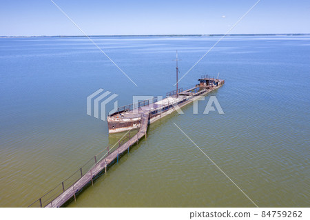 A half-sunken rusty barge at the last berth on the Ob River in Siberia, Russia, in summer 84759262