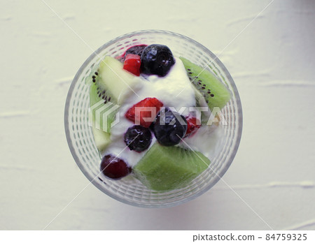 Yogurt sweets with fruit decoration in a glass bowl 84759325
