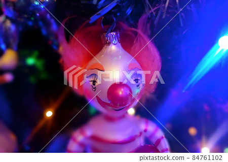 Circus clown glass hand made christmas ball on xmas tree detail blur lights Circus clown glass hand made christmas ball on xmas tree detail blur lights 84761102