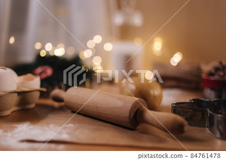 Polling pin for making gingerbread. Close-up of rolling raw dough for gingerbread. Christmas mood. Preparing for hollidays 84761478