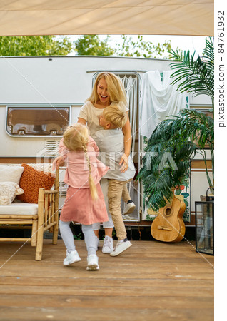Mother and children play at the trailer, camping 84761932