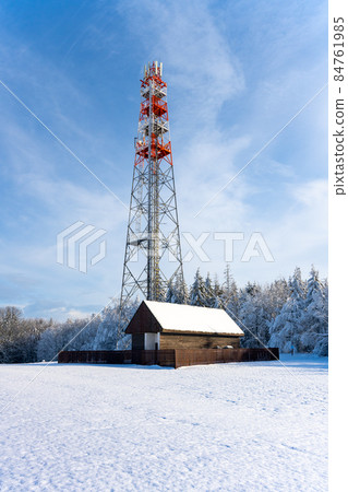 Metal TV transmitter in rural winter landscape 84761985