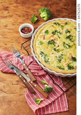 Homemade quiche with red fish, salmon, broccoli and cheese on wooden background Homemade quiche with red fish, salmon, broccoli and cheese on wooden background 84762076