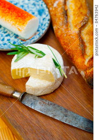 French cheese and fresh baguette on a wood cutter French cheese and fresh baguette on a wood cutter 84763942