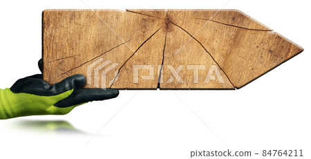Hand with Protective Work Gloves Holding a Wooden Directional Sign 84764211