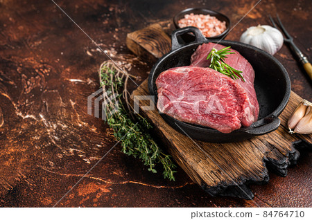 Raw Tenderloin beef fillet meat in a pan with herbs. Dark background. Top view. Copy space Raw Tenderloin beef fillet meat in a pan with herbs. Dark background. Top view. Copy space 84764710