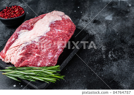 Raw outside Round roast beef meat cut on a marble board. Black background. Top view. Copy space 84764787
