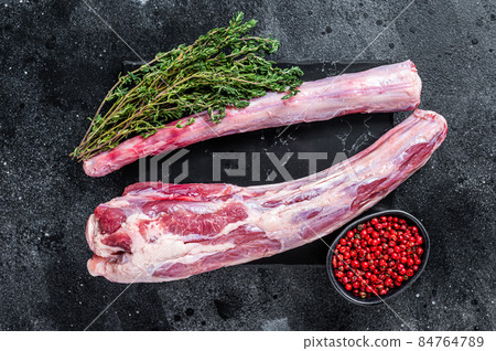 Fresh Raw whole Beef veal Oxtail Meat on marble board with herbs. Black background. Top view Fresh Raw whole Beef veal Oxtail Meat on marble board with herbs. Black background. Top view 84764789