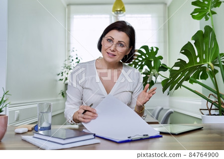 Female teacher businesswoman watching webcam, working online at home office Female teacher businesswoman watching webcam, working online at home office 84764900